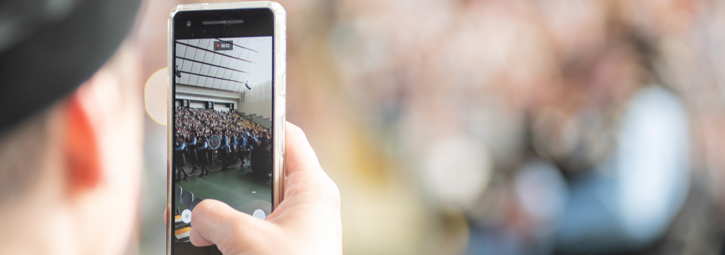 A student records a video on their smartphone.