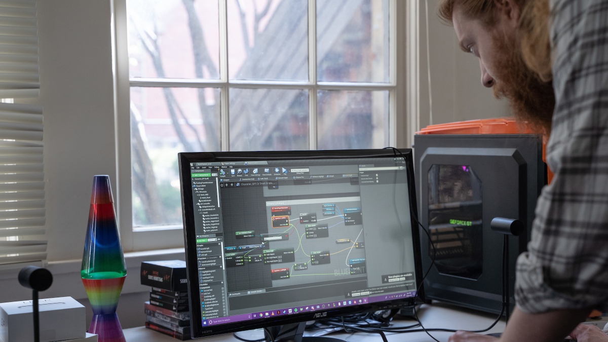 A student works on a computer. The screen shows virtual technology software.
