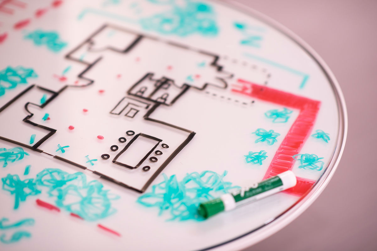 A building floorplan drawn on a whiteboard table.