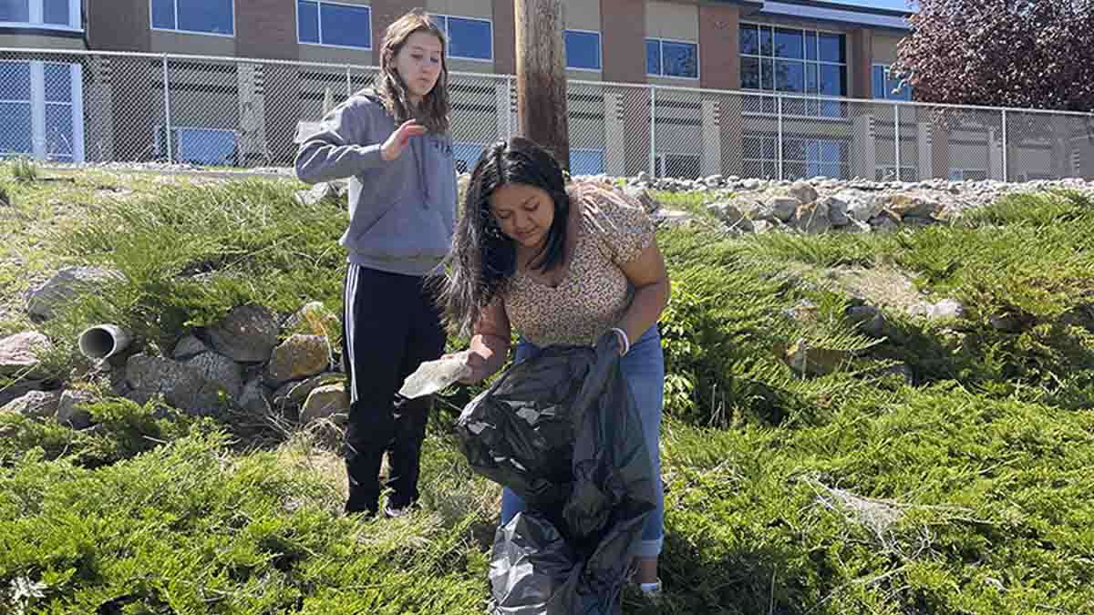 A person picking up trash into a bag.