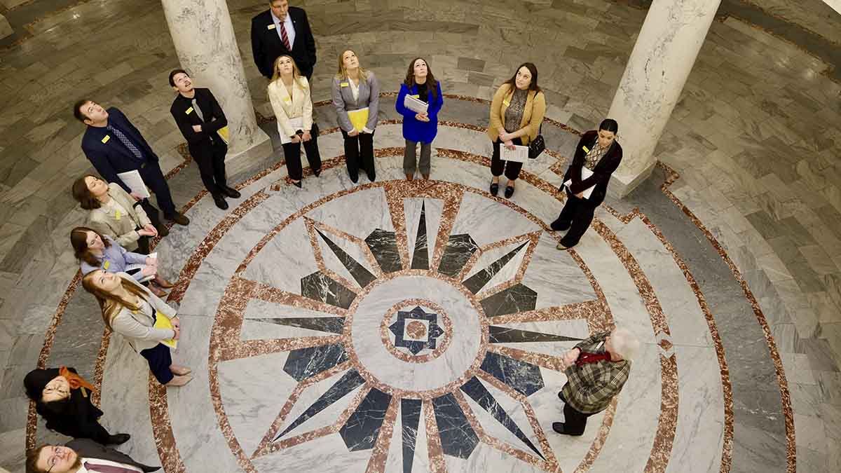 A group of men and women looking up from lobby floor