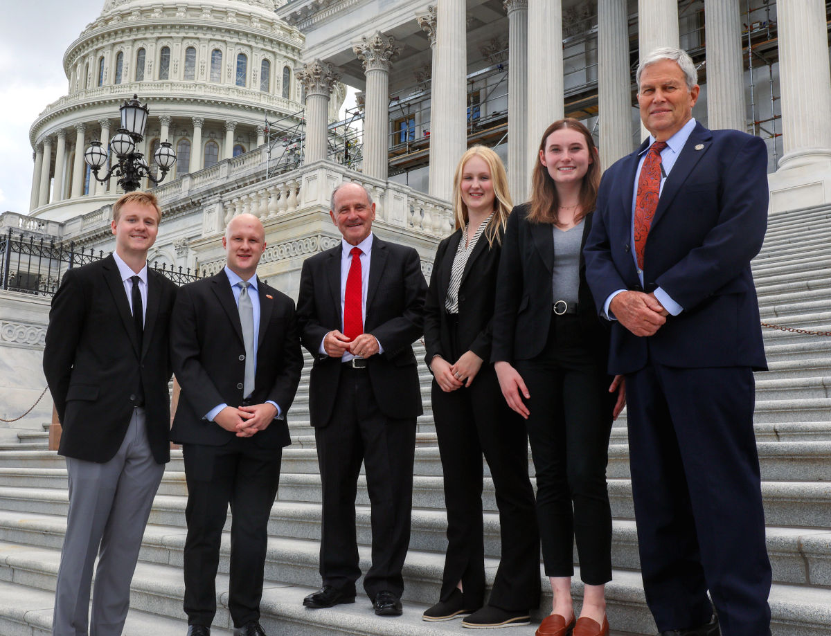 A group of people stand on the steps of the nation’s capital.