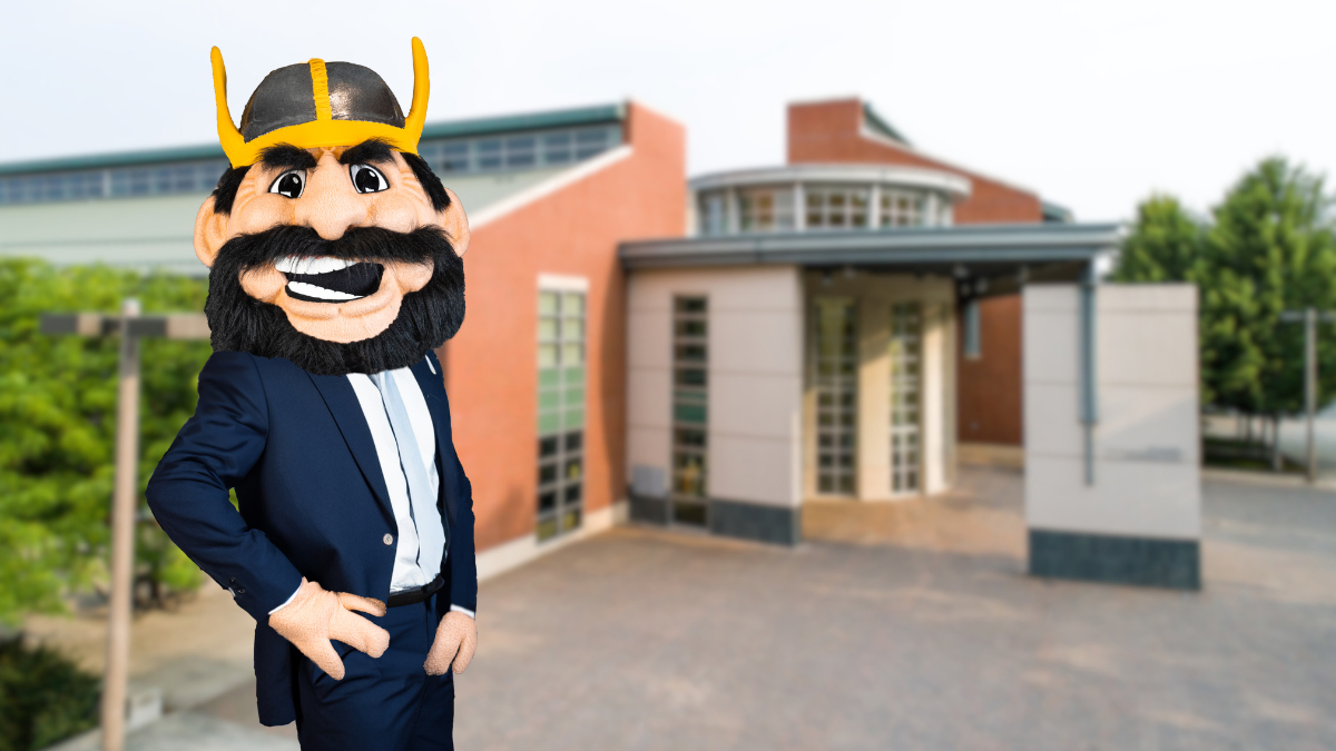 Joe Vandal, in blue business attire, stands before the ISUB