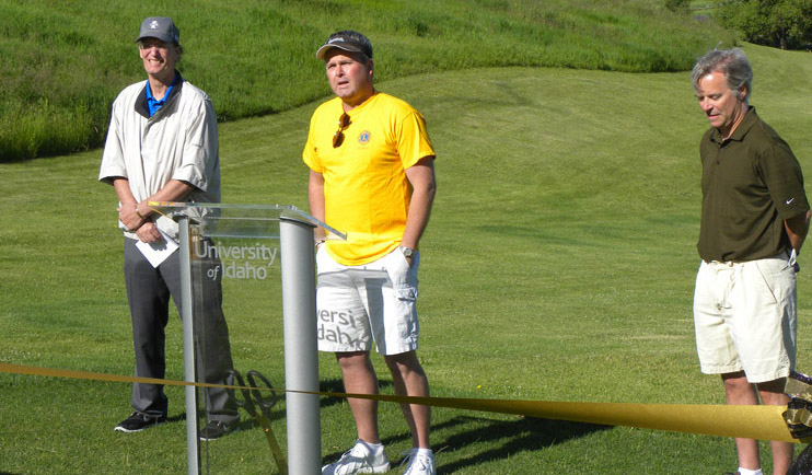 Golf Course Director Doug Tyler on the left and Chip Hunter on the right listen as Moscow Lions Club President speaks