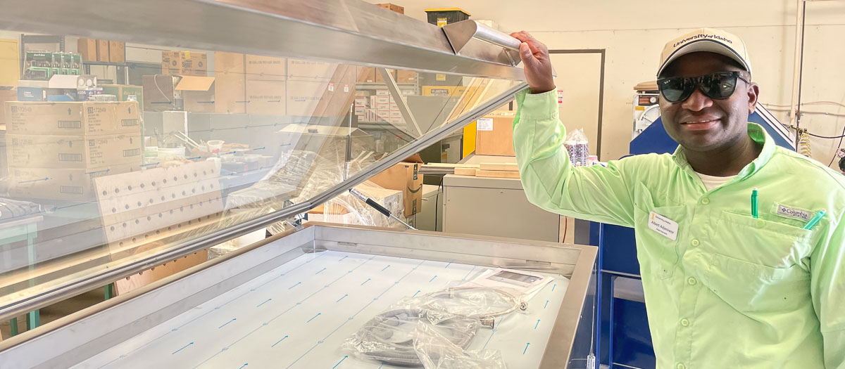 Man stands in front of table with weed samples.