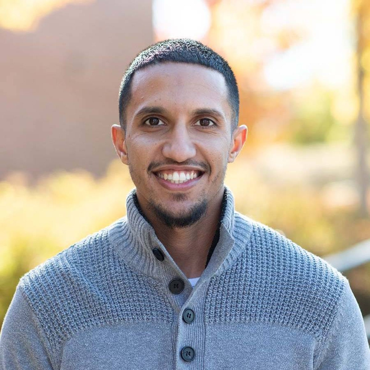 With short hair and a short beard, Sagur smiles for the camera.