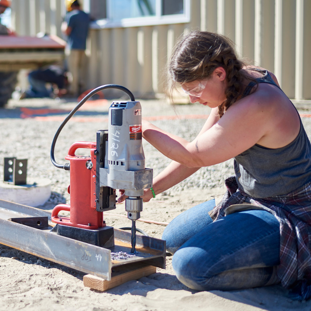 A student drills a piece of metal.