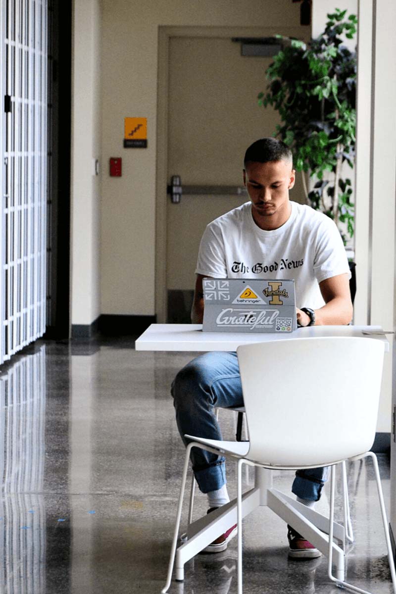 Ben Doucette sits at his computer at a table.