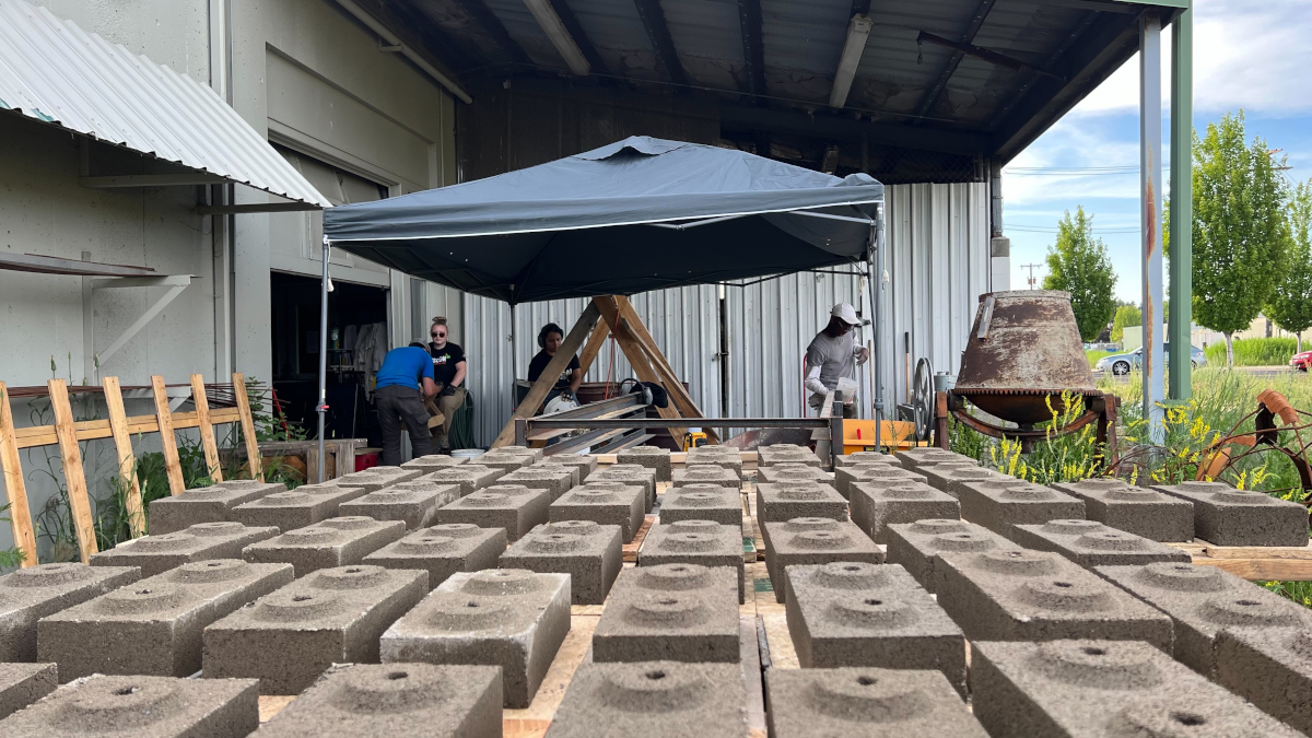 Bricks laying on a table in front of pop up tent.