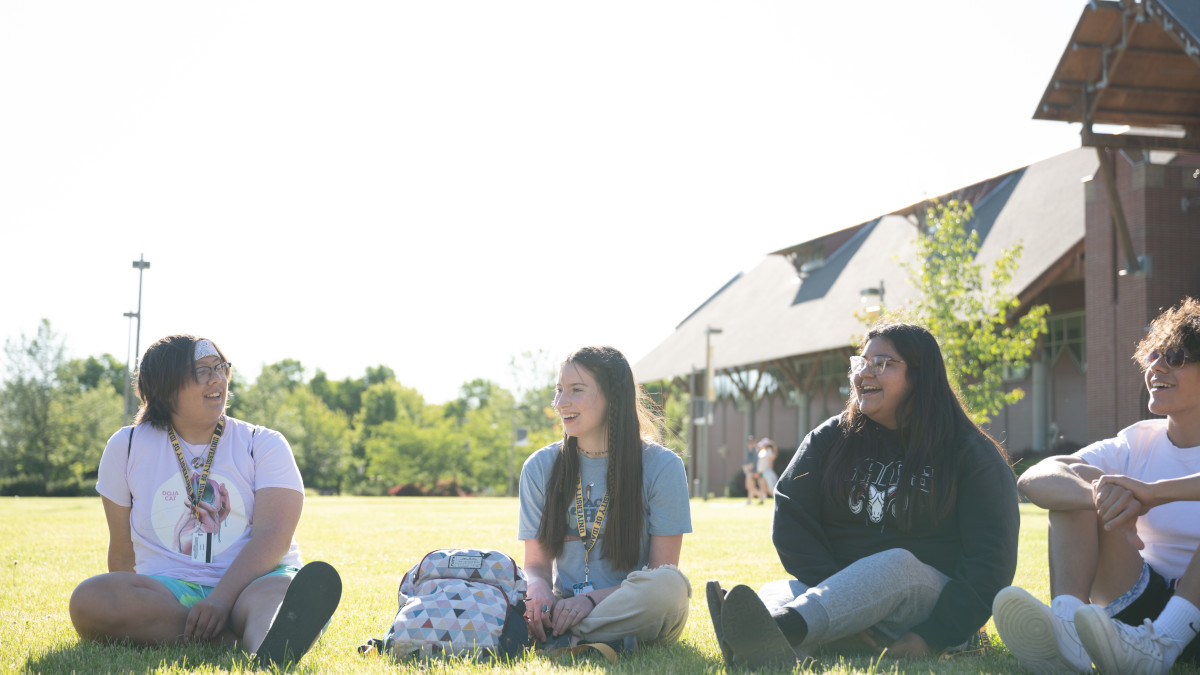 Four students sitting on lawn at U of I.