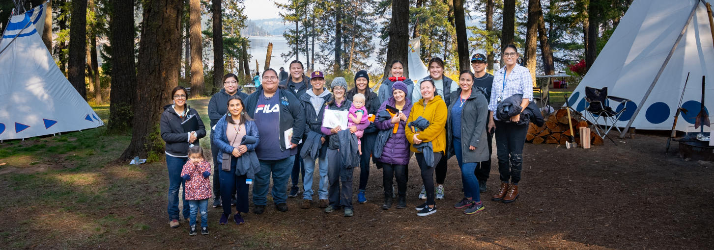 Photo of several people standing in front of trees.