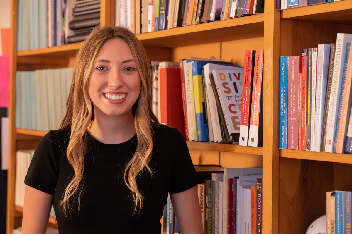 Woman standing in front of bookshelves.