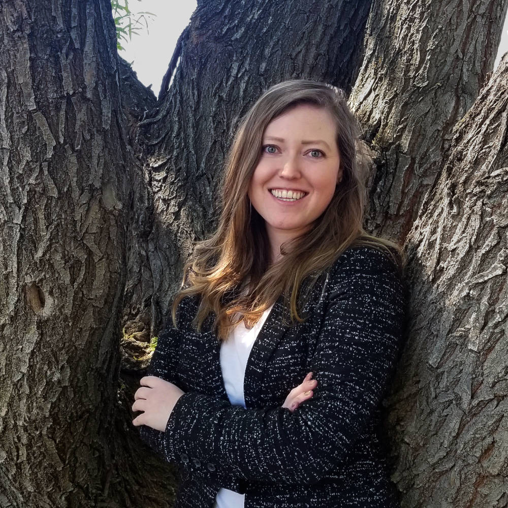 Woman standing in front of a tree.