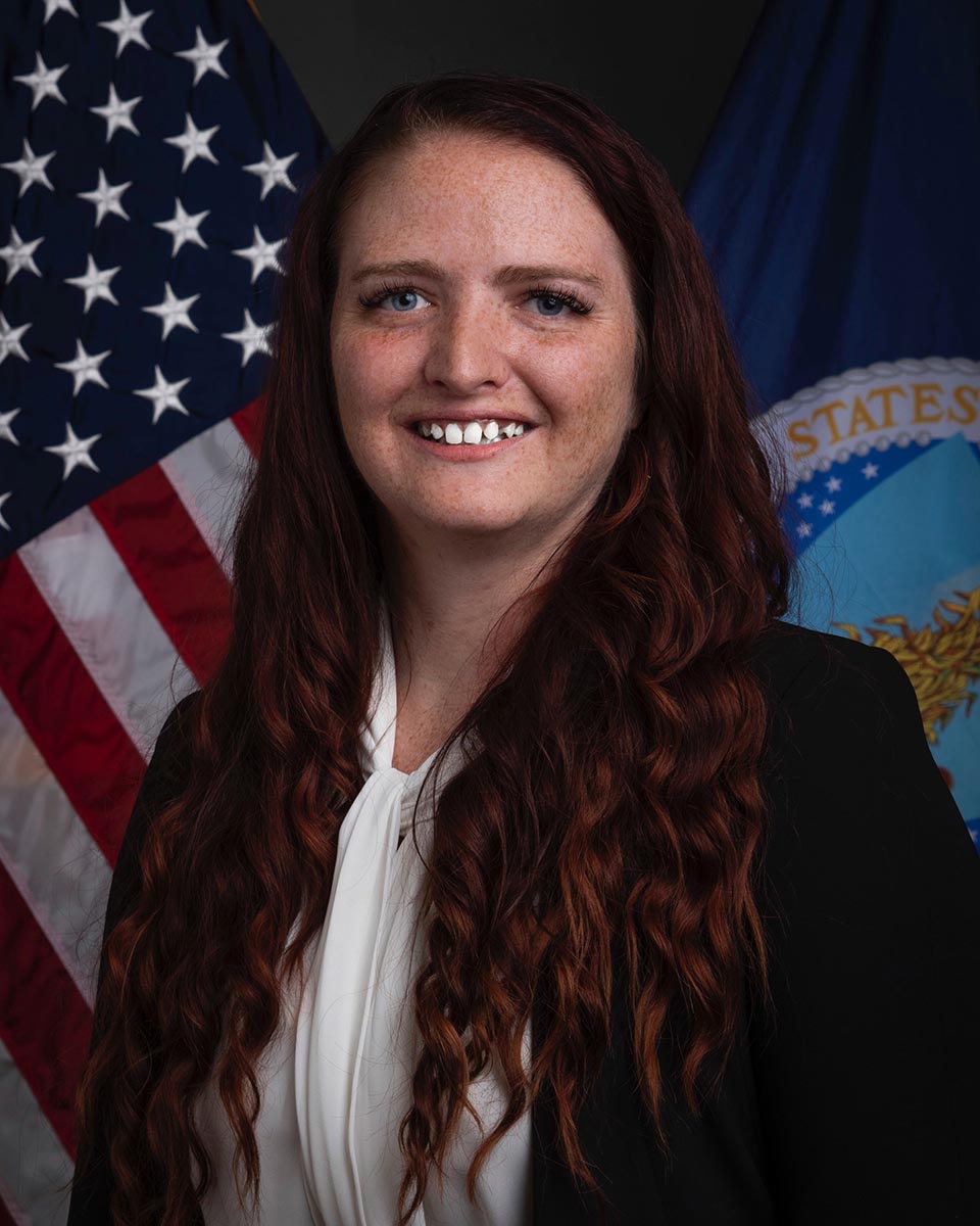 Portrait of woman in front of two flags.