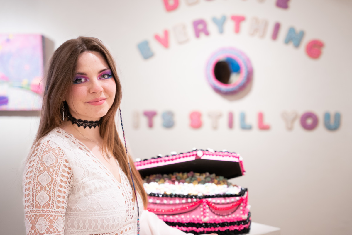 Woman standing in front of one piece of art.