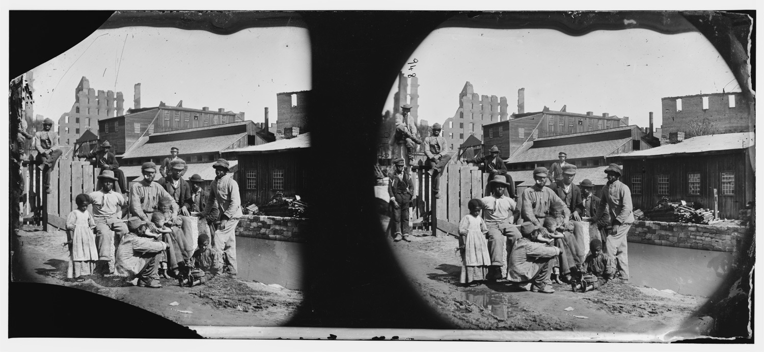 Ten African Americans pose together at the top of an embankment.