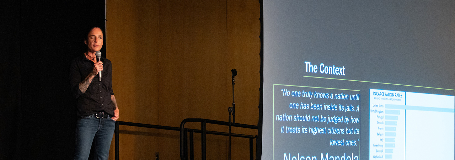 Omi Hodwitz speaks on stage.